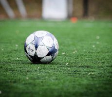 white and blue soccer ball on green grass field during daytime